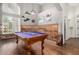 Spacious game room with a pool table, custom wood accent wall, and ample natural light from arched windows at 2058 E Marlene Dr, Gilbert, AZ 85296