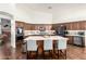 Gourmet kitchen with a center island, seating, stainless steel appliances, and custom tile backsplash at 2058 E Marlene Dr, Gilbert, AZ 85296