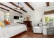 Bright bedroom with wood floors, exposed beams, flat screen TV, and seating area at 2058 E Marlene Dr, Gilbert, AZ 85296