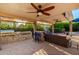 Inviting outdoor kitchen and covered patio with a built-in grill, bar seating, and comfortable lounge area, ideal for entertaining at 2058 E Marlene Dr, Gilbert, AZ 85296