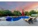 Beautiful backyard pool with lounge chairs, umbrella, and a hot tub surrounded by lush landscaping, perfect for relaxation at 2058 E Marlene Dr, Gilbert, AZ 85296