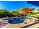 Sparkling pool and spa surrounded by lush landscaping, lounge chairs, and shaded umbrellas at 2058 E Marlene Dr, Gilbert, AZ 85296