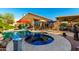 Backyard showcasing the inviting pool, with an attached jacuzzi, surrounded by lush landscaping, and a covered patio at 2058 E Marlene Dr, Gilbert, AZ 85296