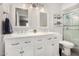 Bathroom featuring dual sinks with updated white vanity and a shower with glass doors at 2312 W Temple St, Chandler, AZ 85224