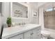 A well-lit bathroom features a framed mirror, white vanity and shower and tub combination at 2312 W Temple St, Chandler, AZ 85224
