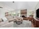 Spacious living room featuring a brick fireplace, plush sofa, and wood-look flooring at 2312 W Temple St, Chandler, AZ 85224