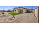 A backyard featuring an artificial turf lawn, gravel, a paved patio, and a view of the home's exterior at 24035 W La Salle St, Buckeye, AZ 85326