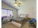 Well-lit bedroom with a vaulted ceiling, fan, large window, bed, and neutral carpeting creating a cozy atmosphere at 24035 W La Salle St, Buckeye, AZ 85326