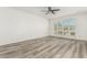 Bright bedroom featuring updated flooring and a large window with plantation shutters at 2437 E North Ln, Phoenix, AZ 85028
