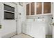 Bright laundry area with white washer/dryer, storage cabinets, and convenient exterior door at 2437 E North Ln, Phoenix, AZ 85028