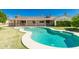 Backyard view of kidney-shaped pool with mature landscaping, and covered patio at 2437 E North Ln, Phoenix, AZ 85028