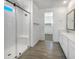 Bright bathroom features a glass-enclosed shower, dual sinks, and ceramic tile flooring at 297 W Tamarack Dr, San Tan Valley, AZ 85140