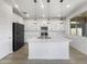 Modern kitchen with white cabinetry, stainless steel appliances, large island and pendant lighting at 297 W Tamarack Dr, San Tan Valley, AZ 85140