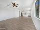 Spacious living room featuring a ceiling fan, and an open floor plan leading into a modern kitchen at 297 W Tamarack Dr, San Tan Valley, AZ 85140