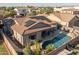 A bird's eye view of a home with a refreshing pool, covered patio, desert landscaping, and solar panels at 3049 E Longhorn Dr, Gilbert, AZ 85297