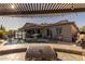 Inviting backyard featuring travertine pavers, a sparkling pool with a waterfall, and outdoor living area with grill at 3049 E Longhorn Dr, Gilbert, AZ 85297
