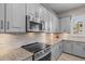 Close up shot of the kitchen with gray cabinets, stainless appliances and granite countertops at 3049 E Longhorn Dr, Gilbert, AZ 85297
