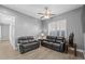 Cozy living room featuring comfortable seating, a ceiling fan, wood-look floors, and plantation shutters at 3049 E Longhorn Dr, Gilbert, AZ 85297
