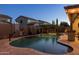 Outdoor kitchen featuring a grill, stone countertop, bar seating and overhead pergola with string lights at 3049 E Longhorn Dr, Gilbert, AZ 85297