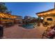 Resort-style backyard featuring a pool, waterfall, covered patio, and an outdoor kitchen and bar at 3049 E Longhorn Dr, Gilbert, AZ 85297