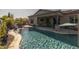 Enjoy the sparkling pool with a rock waterfall and a view of the covered patio and beautiful landscaping at 3049 E Longhorn Dr, Gilbert, AZ 85297