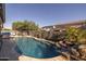 Beautiful pool and backyard, featuring a waterfall, lush landscaping, and outdoor entertaining space at 3049 E Longhorn Dr, Gilbert, AZ 85297