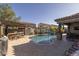 Backyard featuring pool, waterfall, travertine pavers, outdoor kitchen, pergola, and lounging areas for ultimate relaxation at 3049 E Longhorn Dr, Gilbert, AZ 85297