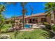 Beautiful backyard oasis featuring a rock waterfall, mature palm trees, and a cozy seating area by the pool at 3622 E Sparrow Pl, Chandler, AZ 85286