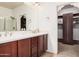 Bathroom featuring a double vanity with wood cabinets and adjacent walk-in closet at 3622 E Sparrow Pl, Chandler, AZ 85286