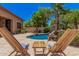 Lounge by the pool in backyard oasis with lush tropical landscaping, rock waterfalls and seating at 3622 E Sparrow Pl, Chandler, AZ 85286