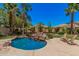 Backyard with a charming pool, rock waterfalls, tropical landscaping, grassy area, and lounge chairs at 3622 E Sparrow Pl, Chandler, AZ 85286