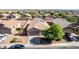 Aerial view of a home's exterior with a two car garage, desert landscaping, and green tree at 40027 W Pryor Ln, Maricopa, AZ 85138