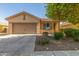 Charming single-story home featuring a neutral-toned exterior, a two-car garage, and low maintenance landscaping at 40027 W Pryor Ln, Maricopa, AZ 85138