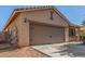 Two-car garage with automatic door, framed by desert landscaping and a neutral color scheme at 40027 W Pryor Ln, Maricopa, AZ 85138