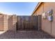 Backyard metal gate surrounded by a block wall featuring a gravel ground at 40027 W Pryor Ln, Maricopa, AZ 85138