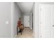 Hallway with neutral paint, featuring a decorative table, leading to various rooms in the home at 40027 W Pryor Ln, Maricopa, AZ 85138