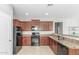 Bright kitchen featuring wooden cabinets, black appliances, and granite countertops at 40027 W Pryor Ln, Maricopa, AZ 85138