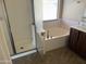 Bathroom featuring a separate glass-enclosed shower and a large soaking tub, vanity, and a window for natural light at 4523 E Gleneagle Dr, Chandler, AZ 85249