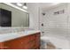 Renovated bathroom with a bathtub, tiled shower and a vanity with marble countertop and dark wood cabinets at 527 N Pasadena --, Mesa, AZ 85201