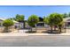 Street view of a charming single story home with covered parking, white exterior and low brick wall surrounding the property at 527 N Pasadena --, Mesa, AZ 85201