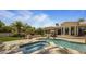 Resort-style backyard featuring a pool, spa, lush landscaping, outdoor seating, and a covered patio at 6305 E Arabian Way, Paradise Valley, AZ 85253