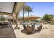 Inviting patio with comfortable seating, outdoor dining area, and views of the sparkling pool and lush landscaping at 6305 E Arabian Way, Paradise Valley, AZ 85253