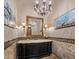 Elegant powder room featuring a stylish vanity, decorative mirror and an ornate chandelier at 6305 E Arabian Way, Paradise Valley, AZ 85253