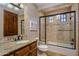 A lovely bathroom with stone tile, a granite counter, and a glass shower door at 6305 E Arabian Way, Paradise Valley, AZ 85253