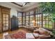 Bright bedroom nook with a view of the pool featuring hardwood floors, windows, and stylish furnishings at 6305 E Arabian Way, Paradise Valley, AZ 85253