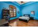 This bedroom, painted blue, features wood floors, a ceiling fan, and a desk area at 6305 E Arabian Way, Paradise Valley, AZ 85253
