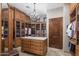 Elegant walk-in closet with custom wood cabinets, shelving, a center island, and a chandelier at 6305 E Arabian Way, Paradise Valley, AZ 85253