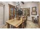 An elegant dining room featuring a rustic wood table, chandelier, and access to the outdoor area at 6305 E Arabian Way, Paradise Valley, AZ 85253