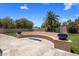 Outdoor patio with a curved seating area featuring a fire pit and lush green landscaping at 6305 E Arabian Way, Paradise Valley, AZ 85253