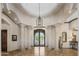 Grand foyer featuring travertine tile floors, stately columns, decorative iron doors, and soaring ceilings at 6305 E Arabian Way, Paradise Valley, AZ 85253